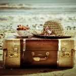 old-suitcase-hat-tea-cup-on-a-beach