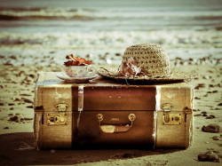 old-suitcase-hat-tea-cup-on-a-beach